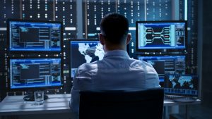 System Security Specialist Working at System Control Center. Room is Full of Screens Displaying Various Information. ICONICS presenta la suite software per l'automazione