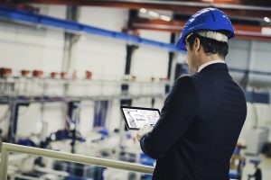 Factory manager supervising production process AI integrata nei robot e manutenzione predittiva